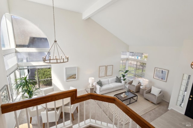 living room featuring baseboards, beam ceiling, carpet flooring, a notable chandelier, and high vaulted ceiling