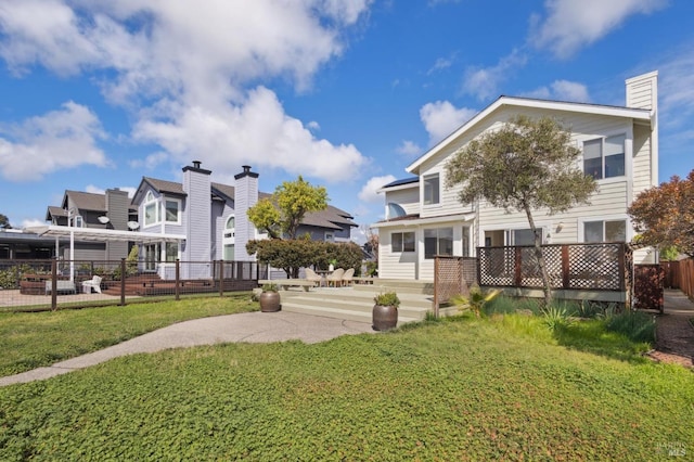 back of property featuring a patio area, a lawn, and fence