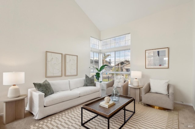 living area with carpet flooring, high vaulted ceiling, and baseboards