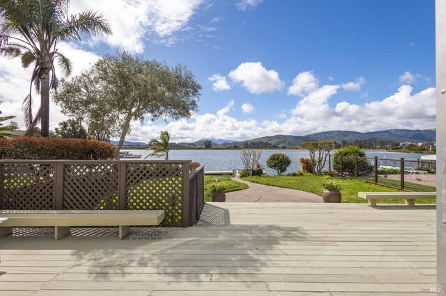 wooden deck featuring a water and mountain view