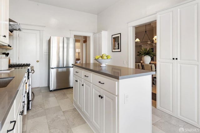 kitchen with stainless steel fridge, a chandelier, white cabinets, and a kitchen island