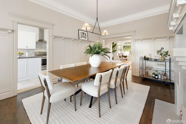 dining area featuring ornamental molding, a chandelier, and dark hardwood / wood-style flooring