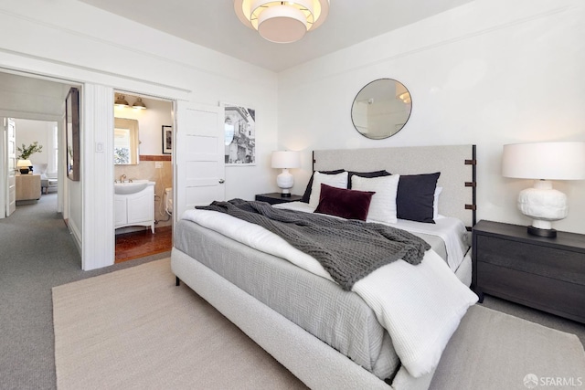 bedroom featuring ensuite bathroom, carpet floors, and sink