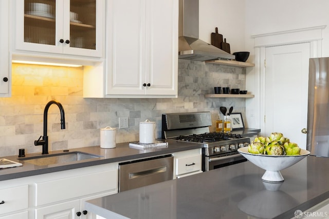 kitchen featuring tasteful backsplash, wall chimney range hood, stainless steel appliances, and sink