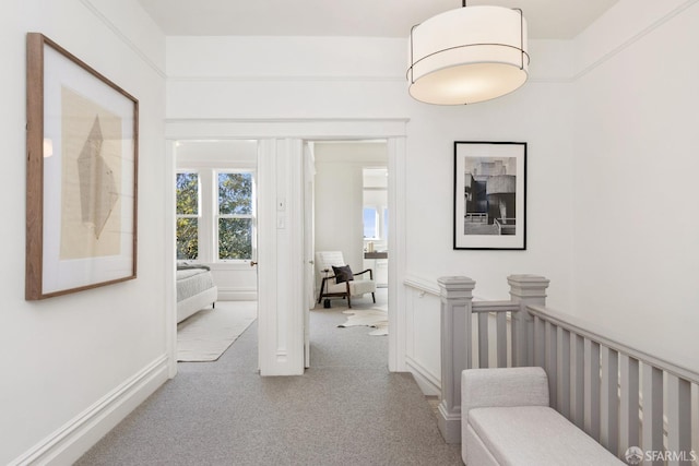 corridor featuring light colored carpet