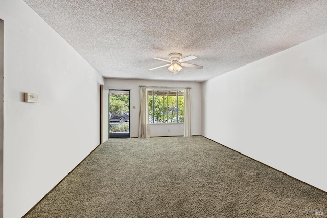 carpeted empty room featuring ceiling fan and a textured ceiling