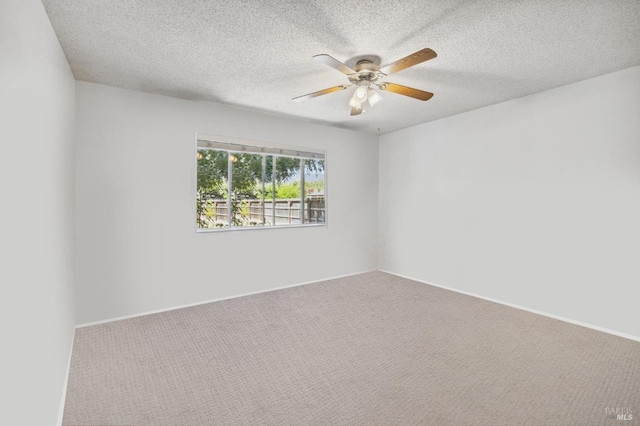 carpeted spare room with ceiling fan and a textured ceiling