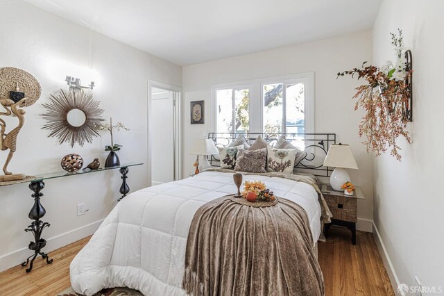 bedroom with light wood-type flooring and baseboards