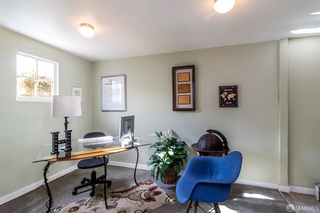 home office with concrete floors and baseboards