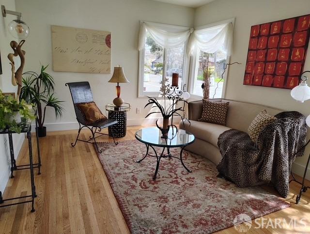 living area with baseboards and wood finished floors