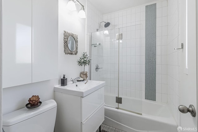 full bath with combined bath / shower with glass door, toilet, and vanity