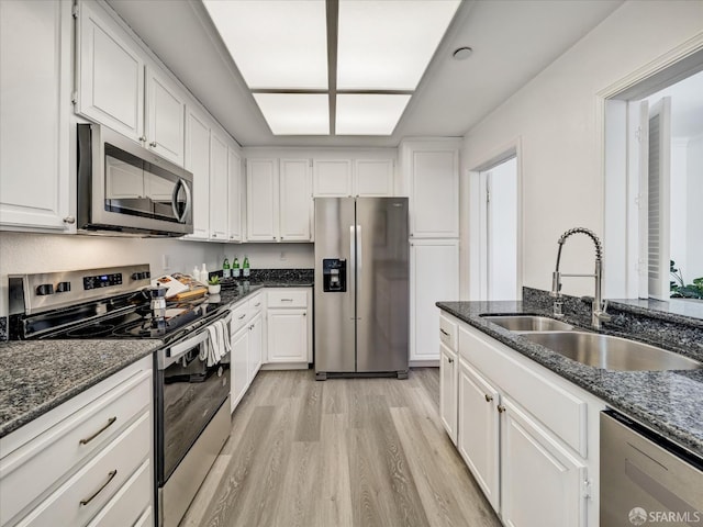 2790 19th Ave Unit 21, San Francisco, CA 94132 - kitchen with stainless steel appliances, light wood-type flooring, white cabinets, and dark stone counters