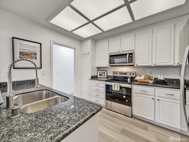 2790 19th Ave Unit 21, San Francisco, CA 94132 - kitchen with stainless steel appliances, white cabinetry, light wood-type flooring, and dark stone countertops