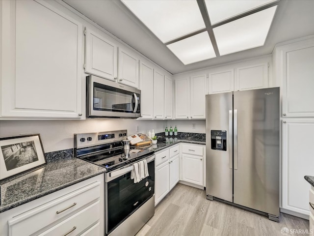 2790 19th Ave Unit 21, San Francisco, CA 94132 - kitchen featuring stainless steel appliances, white cabinets, light wood-style flooring, and dark stone counters