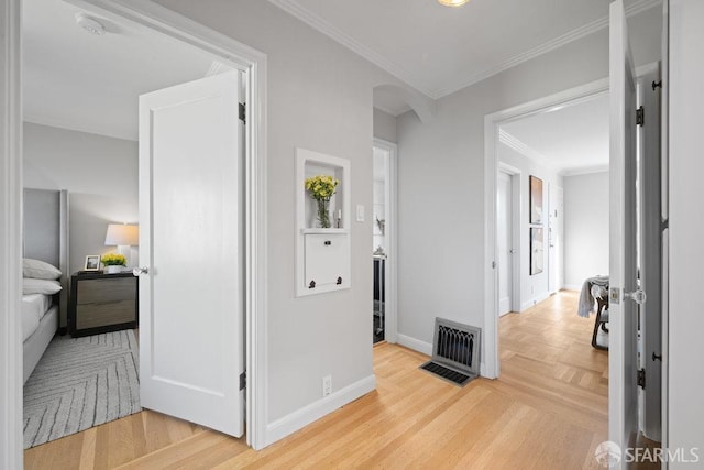 corridor featuring crown molding and light hardwood / wood-style flooring