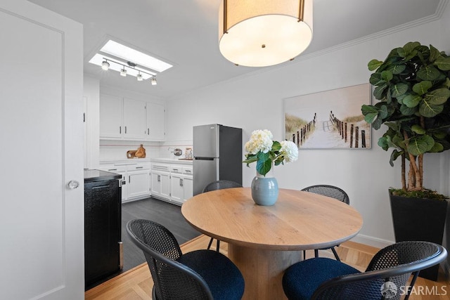 dining area with crown molding and a skylight