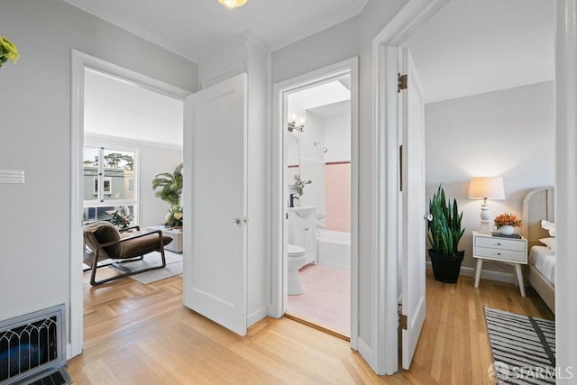 corridor featuring ornamental molding and light hardwood / wood-style floors