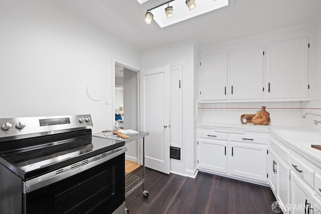 kitchen with sink, stainless steel range with electric cooktop, white cabinetry, tasteful backsplash, and dark hardwood / wood-style floors