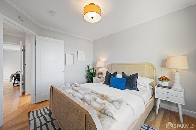 bedroom with crown molding and light hardwood / wood-style flooring