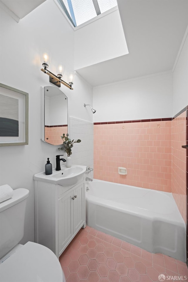 full bathroom featuring a skylight, shower / washtub combination, vanity, tile patterned floors, and toilet