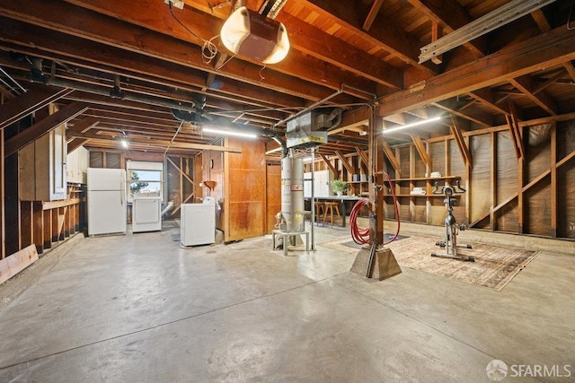 basement featuring white refrigerator and washer and clothes dryer