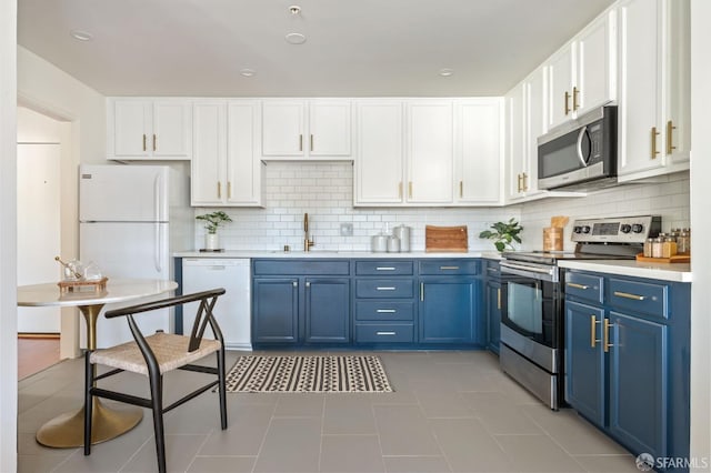 kitchen featuring decorative backsplash, stainless steel appliances, blue cabinets, sink, and white cabinets