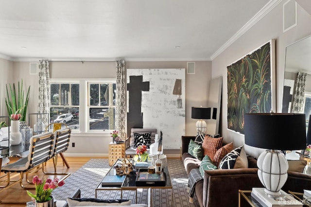 living area with baseboards, visible vents, wood finished floors, a wood stove, and crown molding