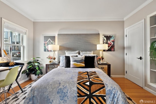 bedroom with crown molding, baseboards, and wood finished floors