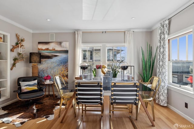 dining room featuring ornamental molding, wood finished floors, and baseboards