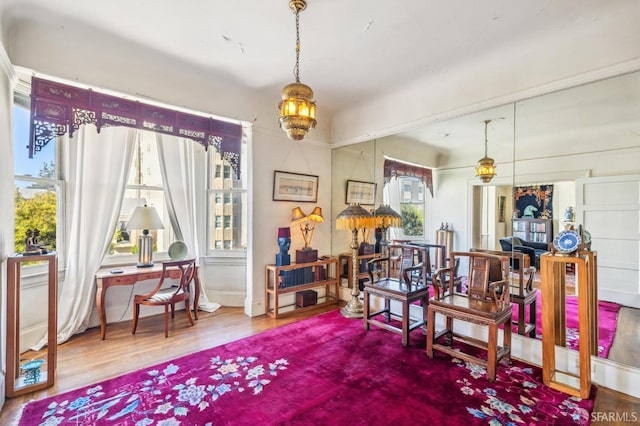 misc room with wood-type flooring, a notable chandelier, and a healthy amount of sunlight