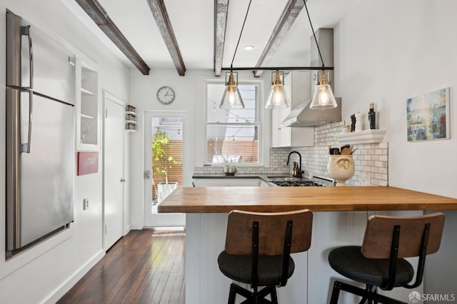50 Perine Pl, San Francisco, CA 94115 - kitchen with butcher block countertops, beam ceiling, decorative backsplash, a breakfast bar, and dark wood finished floors