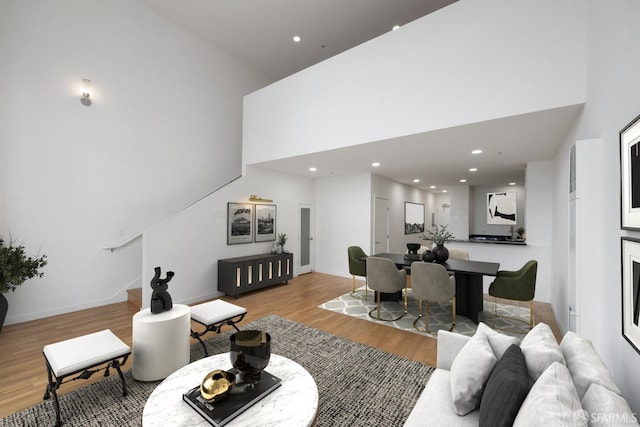 living room featuring a high ceiling and light wood-type flooring