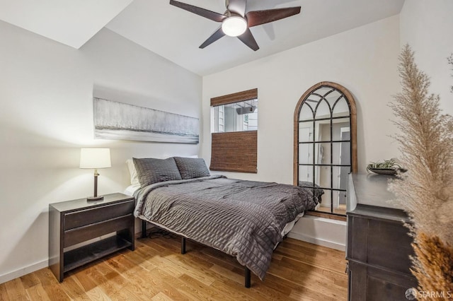 bedroom featuring wood finished floors, a ceiling fan, and baseboards