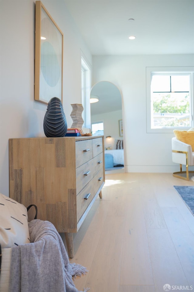 sitting room featuring recessed lighting, baseboards, arched walkways, and light wood-style floors