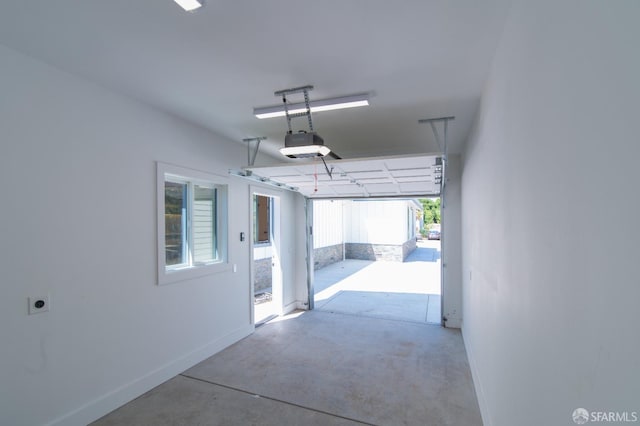 garage featuring a garage door opener and baseboards