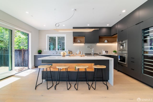 kitchen with modern cabinets, a breakfast bar, open shelves, a sink, and light countertops