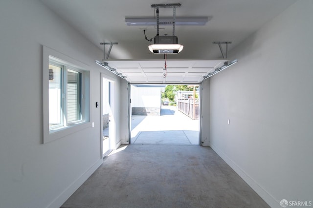 garage featuring a garage door opener and baseboards