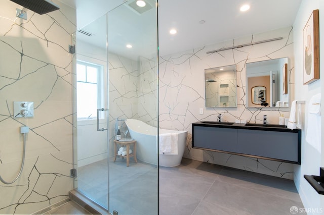 bathroom featuring a marble finish shower, vanity, recessed lighting, a freestanding tub, and tile walls