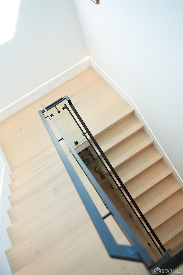 stairs with baseboards and wood finished floors