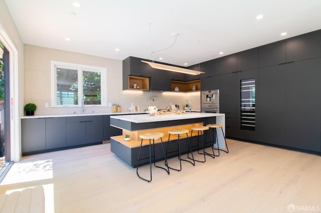 kitchen with a breakfast bar, open shelves, modern cabinets, and light countertops