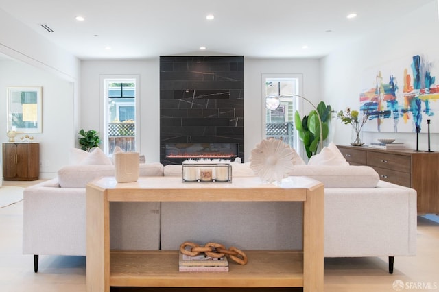 living room featuring recessed lighting, a large fireplace, and wood finished floors