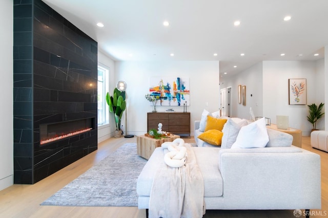 living room with recessed lighting, light wood-style floors, and a fireplace