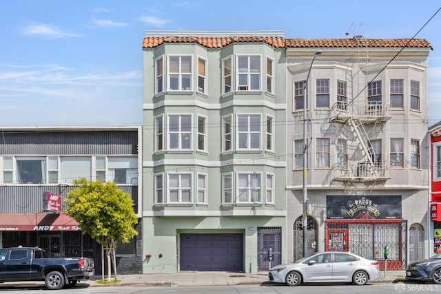 4471 Mission St Unit 2, San Francisco, CA 94112 - view of front of house featuring stucco siding, a tile roof, and an attached garage