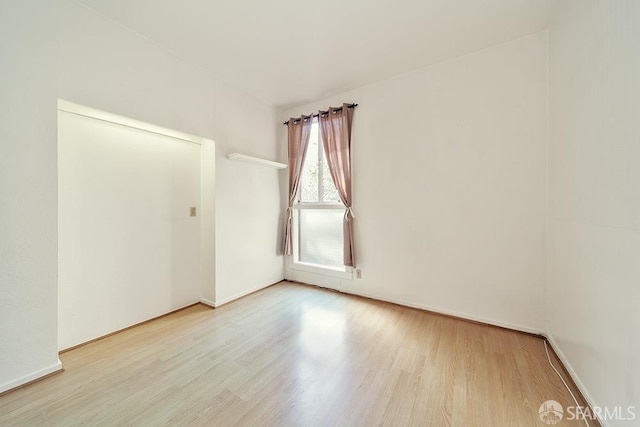 unfurnished room with wood finished floors and baseboards