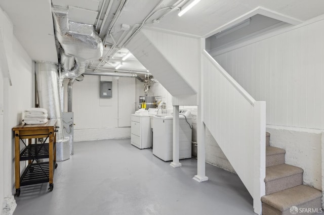 basement with washing machine and clothes dryer and electric panel