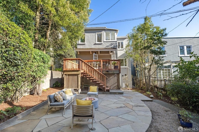 rear view of house featuring a patio, an outdoor living space with a fire pit, and a deck