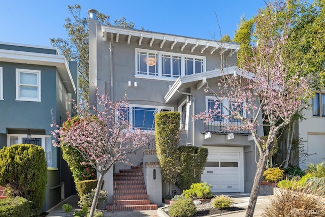 view of property with a balcony and a garage