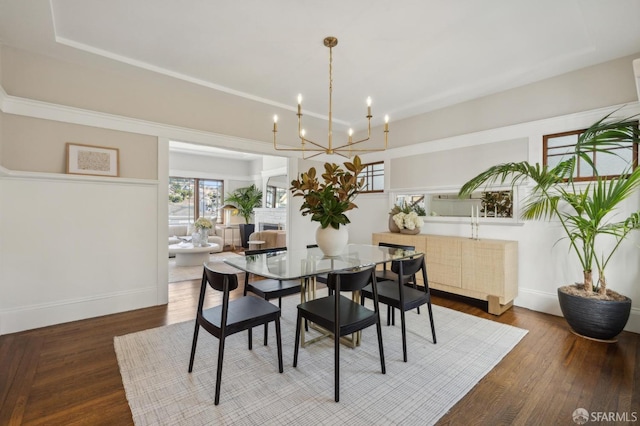 dining area with hardwood / wood-style flooring and an inviting chandelier