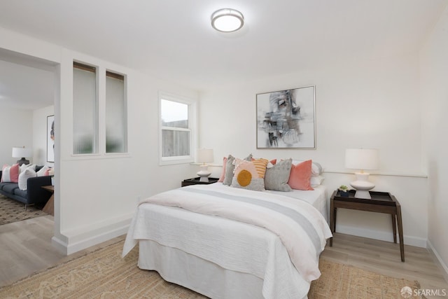 bedroom with light wood-style flooring and baseboards