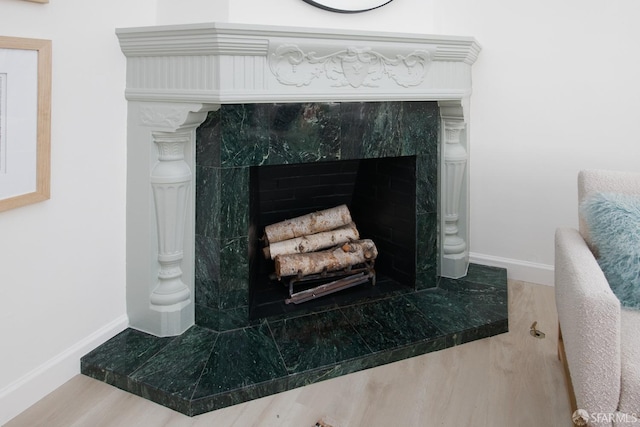 interior details featuring a fireplace, baseboards, and wood finished floors